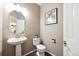 Compact powder room with a pedestal sink, modern toilet, and stylish decor at 13560 Detroit St, Thornton, CO 80241