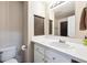 Clean bathroom featuring a toilet, single sink vanity with white countertops, and practical storage solutions at 13560 Detroit St, Thornton, CO 80241