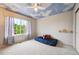 Comfortable bedroom with a sky-themed ceiling and large window, offering a bright and airy atmosphere for relaxation at 13560 Detroit St, Thornton, CO 80241