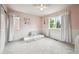 Cozy bedroom with wainscoting, soft pink walls, and natural light streaming through the windows, creating a serene retreat at 13560 Detroit St, Thornton, CO 80241