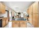 Spacious eat-in kitchen with tile flooring, an island, maple cabinetry, and view to living area at 13560 Detroit St, Thornton, CO 80241