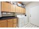 Well-equipped laundry room features built-in cabinets, counter space, and modern washer and dryer at 13560 Detroit St, Thornton, CO 80241