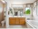 Bright bathroom features a double sink vanity, soaking tub, and a separate glass-enclosed shower at 13560 Detroit St, Thornton, CO 80241