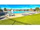 Outdoor community pool, surrounded by greenery, lounge chairs, and tables at 13560 Detroit St, Thornton, CO 80241