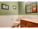 Small bathroom with wood vanity, granite countertop, and green walls at 4618 S Newton St, Denver, CO 80236