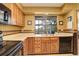 Kitchen features wood cabinets, black appliances, and tile floor at 4618 S Newton St, Denver, CO 80236