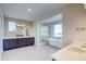 Modern bathroom with double vanity, soaking tub, and glass-enclosed shower at 8596 Hotchkiss St, Littleton, CO 80125