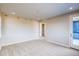 Neutral bedroom with carpet, door to outside deck, bright natural light, and walk-in closet at 8596 Hotchkiss St, Littleton, CO 80125