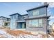 Back exterior of a modern two-story house with blue siding, stone accents, and a balcony at 8596 Hotchkiss St, Littleton, CO 80125