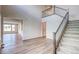 Bright foyer features high ceilings, hardwood floors, a staircase with metal railing, and open access to other rooms at 8596 Hotchkiss St, Littleton, CO 80125