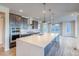 Modern kitchen with stainless steel appliances, quartz countertops, large kitchen island and herringbone backsplash at 8596 Hotchkiss St, Littleton, CO 80125