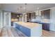 Modern kitchen featuring a large center island, stainless steel appliances, and stylish backsplash at 8596 Hotchkiss St, Littleton, CO 80125