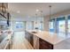 Open-concept kitchen features stainless steel appliances, dark cabinetry, a kitchen island, and hardwood floors at 8596 Hotchkiss St, Littleton, CO 80125