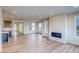 Open-concept living room featuring wood floors, modern fireplace, and lots of natural light at 8596 Hotchkiss St, Littleton, CO 80125