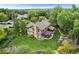 Aerial view showcasing the home's backyard, patio, landscaping, and surrounding trees at 5185 W Fair Pl, Littleton, CO 80123