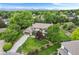 Aerial view of a home with mature trees, a large lawn, landscaping, and mountain views in the distance at 5185 W Fair Pl, Littleton, CO 80123