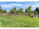 Lush backyard with a well-maintained lawn, stone retaining walls, and mature trees at 5185 W Fair Pl, Littleton, CO 80123