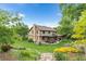 Expansive backyard with a well-maintained lawn, mature trees, and a patio area at 5185 W Fair Pl, Littleton, CO 80123