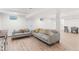 Finished basement with seating area, wood-look floors, and ample lighting at 5185 W Fair Pl, Littleton, CO 80123