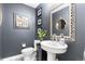 Stylish powder room with dark gray walls, a pedestal sink, and decorative accents at 5185 W Fair Pl, Littleton, CO 80123