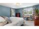 Bedroom with blue walls, patterned curtains, and natural light at 5185 W Fair Pl, Littleton, CO 80123