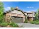 Attractive home with brick and siding, two-car garage, manicured landscaping, and a tiled roof at 5185 W Fair Pl, Littleton, CO 80123