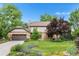 Charming two-story home with brick and siding, mature trees, a well-manicured lawn, and a two-car garage at 5185 W Fair Pl, Littleton, CO 80123