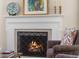 Close-up of a lit fireplace with mantel and decorative accessories, creating a warm ambiance at 5185 W Fair Pl, Littleton, CO 80123