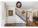 Welcoming home foyer featuring hardwood floors, staircase, wainscoting, and elegant lighting at 5185 W Fair Pl, Littleton, CO 80123