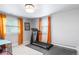 Home gym featuring a treadmill, natural lighting, and orange curtains at 5185 W Fair Pl, Littleton, CO 80123