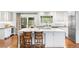 Bright kitchen with white cabinets, a marble countertop island with seating, and stainless steel appliances at 5185 W Fair Pl, Littleton, CO 80123