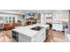 Bright kitchen with white cabinets, a marble countertop island with stainless steel appliances, and hardwood floors at 5185 W Fair Pl, Littleton, CO 80123