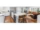 Bright kitchen featuring white cabinets, hardwood floors, a marble countertop island, and stainless steel appliances at 5185 W Fair Pl, Littleton, CO 80123
