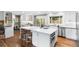 Spacious kitchen with white cabinets, marble countertops, stainless steel appliances, and hardwood floors at 5185 W Fair Pl, Littleton, CO 80123