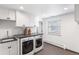 Bright laundry room with modern appliances, white cabinets, and tiled flooring at 5185 W Fair Pl, Littleton, CO 80123