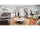 Bright open concept living room with white kitchen, hardwood floors, and a comfortable seating area at 5185 W Fair Pl, Littleton, CO 80123