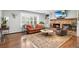 Comfortable living room with a brick fireplace, a brown leather couch, and a large window at 5185 W Fair Pl, Littleton, CO 80123