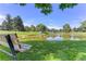 A community pond with a bench to enjoy nature with views of a lush green area and trees at 5185 W Fair Pl, Littleton, CO 80123