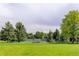 A serene view of community tennis courts with picnic seating and mature trees and grass at 5185 W Fair Pl, Littleton, CO 80123