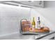 Stylish wet bar featuring a stainless steel sink, subway tile backsplash, and custom cabinetry at 5185 W Fair Pl, Littleton, CO 80123