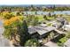 This aerial view captures the home with lush landscaping, adjacent to a serene lake, and views of the Denver skyline at 1901 Meade St, Denver, CO 80204