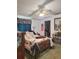 Bedroom with patterned bedding, ceiling fan, and walk-in closet at 313 W 3Rd Ave, Byers, CO 80103