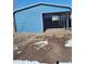 Open carport with a blue exterior and gravel base at 313 W 3Rd Ave, Byers, CO 80103