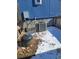 View of the home's blue siding, with A/C unit, electrical box, and wood fence at 313 W 3Rd Ave, Byers, CO 80103