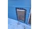 Close up of a secured blue metal pet door, designed for all-weather protection at 313 W 3Rd Ave, Byers, CO 80103