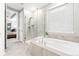 Bright bathroom featuring a soaking tub and walk-in shower with a glass enclosure at 18922 W 84Th Ave, Arvada, CO 80007