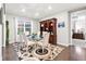 Dining room with modern rug, glass table, and upholstered chairs next to large window at 18922 W 84Th Ave, Arvada, CO 80007