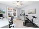 Home office featuring a ceiling fan, desk, exercise bike, and a large window at 18922 W 84Th Ave, Arvada, CO 80007