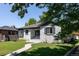 Beautiful white brick exterior with manicured lawn and winding sidewalk to the covered entry of this home at 2995 N Cherry St, Denver, CO 80207