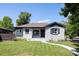 Charming exterior of a ranch-style home with a manicured lawn, whitewashed brick, and updated black trim at 2995 N Cherry St, Denver, CO 80207